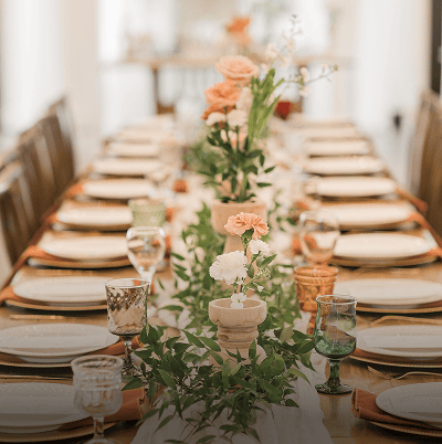 Long dining table with flowers and glassware